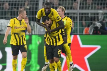 Dortmund's Serhou Guirassy, top, celebrates with Emre Can after scoring his side's fourth goal during the Champions League opening phase soccer match between Borussia Dortmund and Celtic FC at the BVB Stadion in Dortmund, Germany, Tuesday, Oct. 1, 2024. (AP Photo/Martin Meissner)