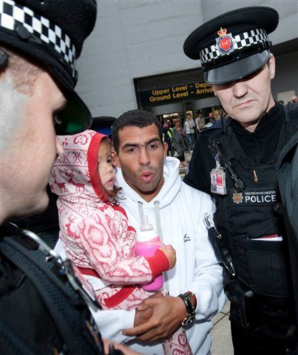 Footballer Carlos Tevez arrives at Manchester Airport, Manchester, England, Tuesday, Feb. 14, 2012. Its is reported that Tevez, who has been in Argentina without his club's permission since November 7, will resume his Manchester City career despite accusing manager Roberto Mancini of treating him "like a dog" in the incident that sparked their rift. (AP Photo/Jon Super)