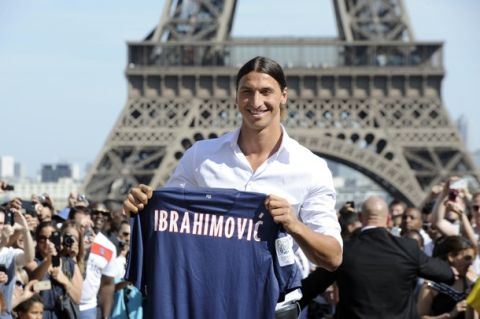 Paris Saint-Germain (PSG) football club's newly recruited Sweden striker Zlatan Ibrahimovic poses with his shirt in front of the Eiffel tower on July 18, 2012 in Paris.  AFP PHOTO / BERTRAND GUAY        (Photo credit should read BERTRAND GUAY/AFP/GettyImages)