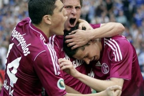 Schalke's Julian Draxler, right, celebrates his sides opening goal with his teammates Kyriakos Papadopoulos, left, and Benedikt Hoewedes, center, during the German Soccer Cup final between MSV Duisburg and FC Schalke 04 in Berlin, Germany, Saturday, May 21, 2011. (AP Photo/Michael Sohn)