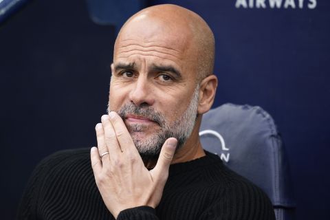 Manchester City's head coach Pep Guardiola takes his seat before the English Premier League soccer match between Manchester City and Arsenal at the Etihad stadium in Manchester, England, Sunday, Sept. 22, 2024. (AP Photo/Dave Thompson)