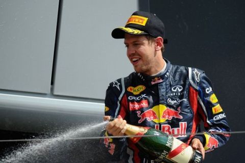 NORTHAMPTON, UNITED KINGDOM - JULY 10:  Second placed Sebastian Vettel of Germany and Red Bull Racing celebrates on the podium following the British Formula One Grand Prix at the Silverstone Circuit on July 10, 2011 in Northampton, England.  (Photo by Clive Mason/Getty Images)