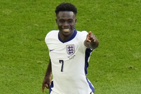 England's Bukayo Saka celebrates after scoring his side's opening goal during a quarterfinal match between England and Switzerland at the Euro 2024 soccer tournament in Duesseldorf, Germany, Saturday, July 6, 2024. (AP Photo/Hassan Ammar)