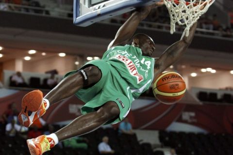 Cote d'Ivoire's Guy Landry Edi hangs on the rim after dunking the ball during their FIBA Basketball World Championship game against China in Ankara August 29, 2010.            REUTERS/Mark Blinch (TURKEY  - Tags: SPORT SPORT BASKETBALL)