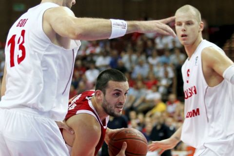 epa02298155 Poland's Marcin Gortat (L) and Maciej Lampe (R) look on as Filip Videnov (C) of Bulgaria dives through their defence during their elimination match to the men's Basketball European Championships in Katowice, Poland, 23 August 2010.  EPA/ANDRZEJ GRYGIEL POLAND OUT