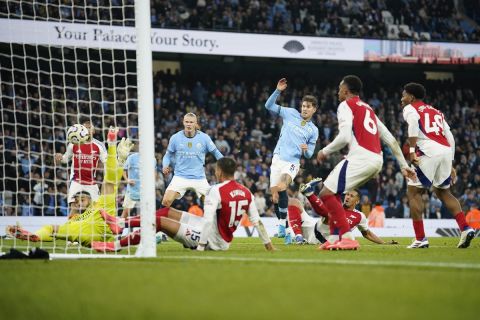 Manchester City's John Stones, center, scores his side's second goal during the English Premier League soccer match between Manchester City and Arsenal at the Etihad stadium in Manchester, England, Sunday, Sept. 22, 2024. (AP Photo/Dave Thompson)