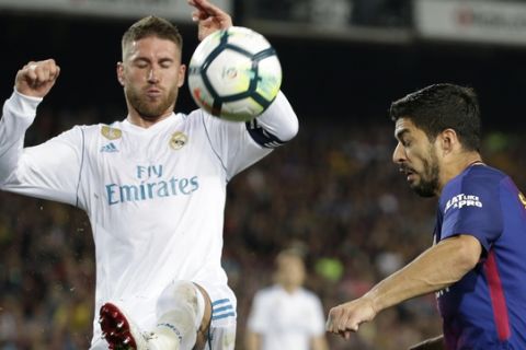 Barcelona's Luis Suarez, right, and Real Madrid's Sergio Ramos vie for the ball during a Spanish La Liga soccer match between Barcelona and Real Madrid, dubbed 'El Clasico', at the Camp Nou stadium in Barcelona, Spain, Sunday, May 6, 2018. (AP Photo/Emilio Morenatti)