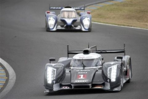 The Audi R18 TDI No1 driven by French driver Romain Dumas, Timo Bernhard and Mike Rockenfeller both of Germany is seen in action ahead of the Peugeot No9 driven by Sebastien Bourdais, Simon Pagenaud, both of France, and Pedro Lamy of Portugal at the start of the 79th 24-hour Le Mans endurance race, in Le Mans, western France, Saturday, June 11, 2011. (AP Photo/Vincent Michel)