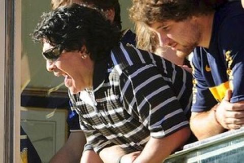 Argentina's coach Diego Maradona, second from right, cheers prior to an Argentinean soccer league match between Boca Juniors and River Plate in Buenos Aires, Thursday  March 25, 2010. (AP Photo/Jorge Araujo)