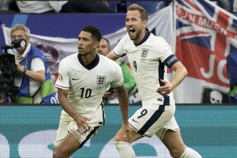 England's Jude Bellingham celebrates with Harry Kane, right, after scoring his side's first goal during a round of sixteen match between England and Slovakia at the Euro 2024 soccer tournament in Gelsenkirchen, Germany, Sunday, June 30, 2024. (AP Photo/Thanassis Stavrakis)
