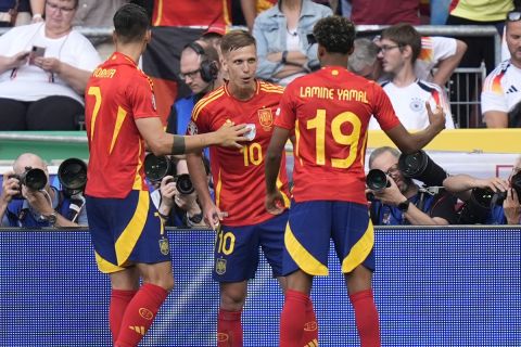 Spain's Dani Olmo, center, celebrates after scoring the opening goal during a quarter final match between Germany and Spain at the Euro 2024 soccer tournament in Stuttgart, Germany, Friday, July 5, 2024. (AP Photo/Matthias Schrader)
