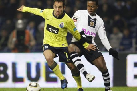 Porto's Fernando Belluschi (L) battles for the ball with Nacional's Juninho Arcanjo during their Portuguese Premier League soccer match at Dragao stadium in Porto January 26, 2011. REUTERS/Miguel Vidal (PORTUGAL - Tags: SPORT SOCCER)