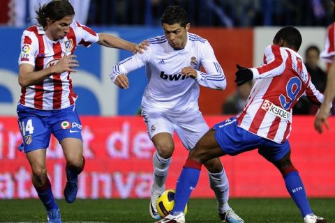 Real Madrid's Portuguese forward Cristiano Ronaldo (C) vies with Atletico Madrid's Brazilian defender Filipe (L) and Atletico Madrid's Brazilian midfielder Elias (R) during the Spanish King's Cup (Copa del Rey) football match Atletico de Madrid vs Real Madrid on January 20, 2011 at the Vicente Calderon stadium in Madrid.    AFP PHOTO/ PIERRE-PHILIPPE MARCOU (Photo credit should read PIERRE-PHILIPPE MARCOU/AFP/Getty Images)