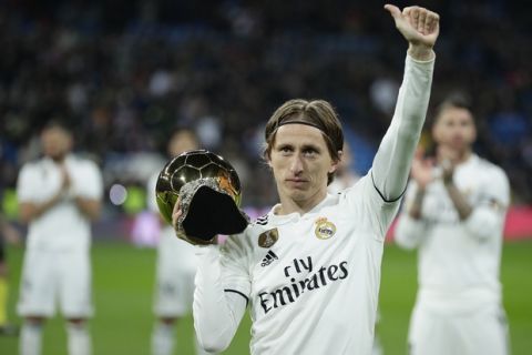 Real Madrid's Luka Modric holds up his Ballon d'Or (Golden Ball) award as European Footballer of the Year prior of he Spanish La Liga soccer match between Real Madrid and Rayo Vallecano at the Bernabeu stadium in Madrid, Spain, Saturday, Dec. 15, 2018. (AP Photo/Manu Fernandez)