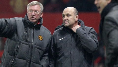 Manchester United manager Alex Ferguson, left, talks with assistant manager Mike Phelan as Valencia manager Unai Emery, right, looks on during their Champions League Group C soccer match at Old Trafford, Manchester, England, Tuesday Dec. 7, 2010. (AP Photo/Jon Super)