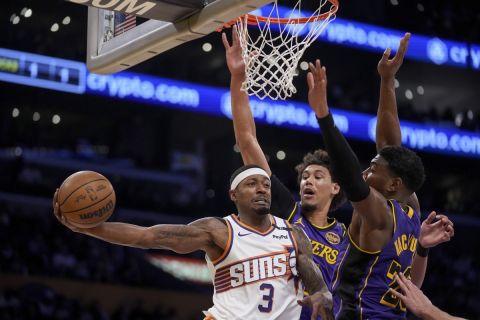 Phoenix Suns guard Bradley Beal (3) passes around Los Angeles Lakers center Jaxson Hayes and forward Rui Hachimura during the first half of an NBA basketball game against the in Los Angeles, Friday, Oct. 25, 2024. (AP Photo/Eric Thayer)