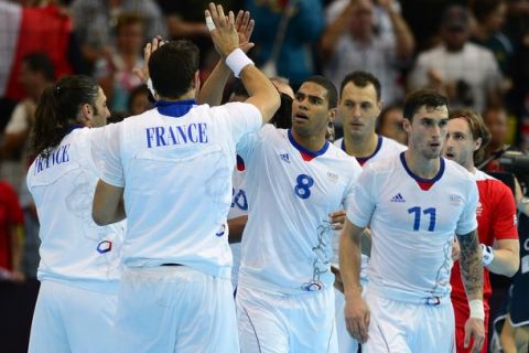 France's centreback Daniel Narcisse (2ndR) highfive with teammates as he celebrates their victory over Great Britain by 44-15 at the end of the men's preliminaries Group A handball match France vs Great Britain for the London 2012 Olympics Games on July 29, 2012 at the Copper Box hall in London.     AFP PHOTO/ JAVIER SORIANO        (Photo credit should read JAVIER SORIANO/AFP/GettyImages)