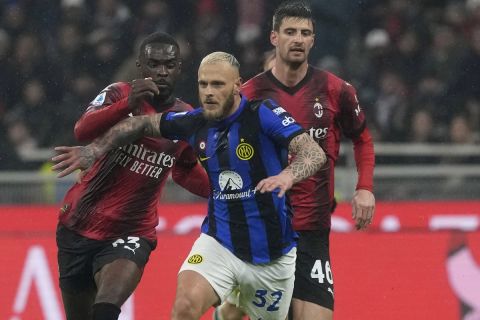 Inter Milan's Federico Dimarco, center, is challenged by AC Milan's Fikayo Tomori, left, and AC Milan's Matteo Gabbia during a Serie A soccer match between AC Milan and Inter Milan at the San Siro stadium in Milan, Italy, Monday, April 22, 2024. (AP Photo/Luca Bruno)