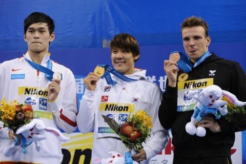 Gold medalist South Korea's Park Tae-Hwan (C), silver medalist China's Sun Yang (L) and bronze medalist Germany's Paul Biedermann pose during the medal ceremony for men's 400-metre freestyle swimming event in the FINA World Championships at the indoor stadium of the Oriental Sports Center, in Shanghai, on July 24, 2011.  AFP PHOTO / PETER PARKS (Photo credit should read PETER PARKS/AFP/Getty Images)