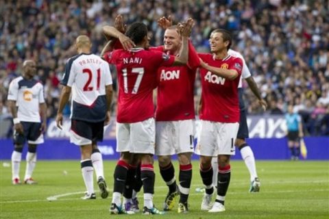 Manchester United's Wayne Rooney, centre right, celebrates with teammates after scoring his third goal against Bolton during their English Premier League soccer match at The Reebok Stadium, Bolton, England, Saturday Sept. 10, 2011. (AP Photo/Jon Super)