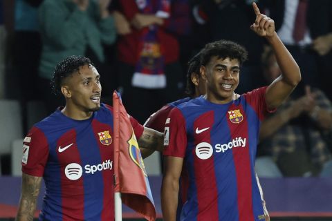 Barcelona's Lamine Yamal, right, celebrates with Raphinha after scoring the opening goal during a Spanish La Liga soccer match between Barcelona and Real Sociedad at the Olimpic Lluis Companys stadium in Barcelona, Spain, Monday, May 13, 2024. (AP Photo/Joan Monfort)