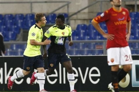 FC Basel defender Samuel Inkoom, of Ghana,  is congratulated by his teammate Xherdan Shaqiri, left, after scoring during the Champions League, Group E soccer match between AS Roma and FC Basel, at the Rome Olympic stadium Tuesday, Oct. 19, 2010. At right, foreground, is AS Roma midfielder Simone Perrotta. (AP Photo/Pier Paolo Cito) 