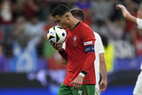 Portugal's Cristiano Ronaldo kiss the ball before kick a penalty during a round of sixteen match between Portugal and Slovenia at the Euro 2024 soccer tournament in Frankfurt, Germany, Monday, July 1, 2024. (AP Photo/Matthias Schrader)