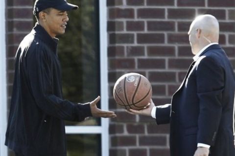 President Barack Obama is handed a personalized basketball by a military aide as he arrives for a private game of basketball at Fort McNair in Washington, Saturday, Sept. 18, 2010. (AP Photo/Charles Dharapak)