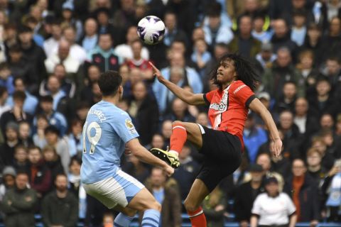 Luton Town's Tahith Chong, right, kicks the ball ahead of Manchester City's Julian Alvarez during the English Premier League soccer match between Manchester City and Luton Town at Etihad stadium in Manchester, England, Saturday, April 13, 2024. (AP Photo/Rui Vieira)